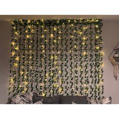 a living room filled with furniture and lots of greenery on the wall behind it