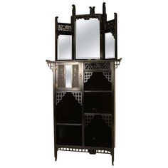 an ornate wooden cabinet with mirrors on the top and bottom shelves, in black lacquer