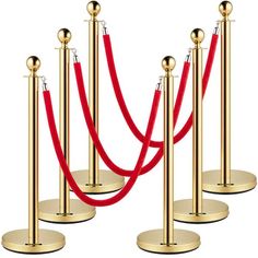 three gold poles with red ropes on them