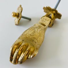 two pieces of gold colored metal with designs on them, one has a screwdriver in the middle