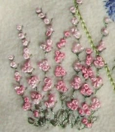 three different types of flowers on a white cloth with beadwork and sequins