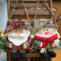 two christmas decorations sitting on top of a wooden bench