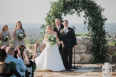 a bride and groom walking down the aisle at their outdoor wedding ceremony with guests watching