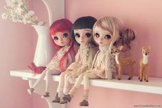 three dolls are sitting on a shelf next to each other and one is holding a deer