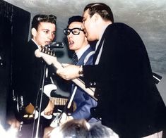 two men singing into microphones in front of a crowd