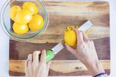 someone using a grater to cut lemons on a cutting board