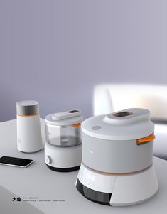 three appliances sitting on top of a white table next to a cell phone and tablet