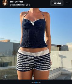 a woman in blue and white swimsuit standing on rooftop