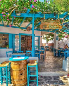 an outdoor restaurant with blue tables and chairs