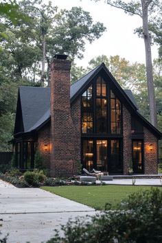 a large brick house with lots of windows and lights on it's front porch