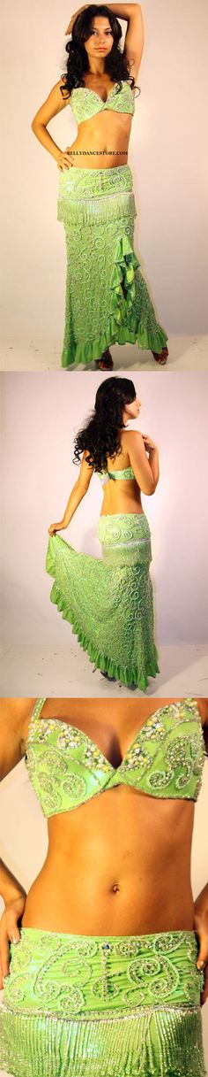 a woman in a green belly dance outfit with her hands on her hips and the bottom half of her body