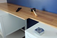 a wooden desk with two tools on it and a blue wall in the back ground