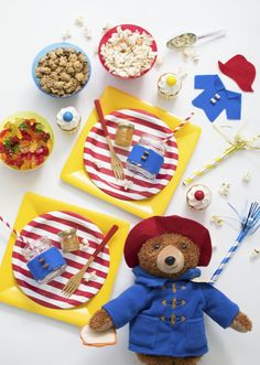 a teddy bear sitting on top of two plates filled with food and candy barbeque