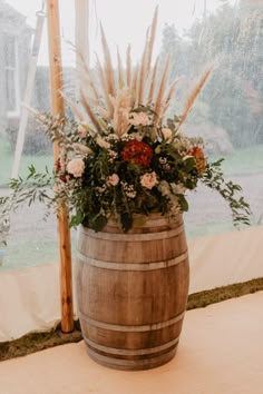 a wooden barrel filled with flowers and greenery