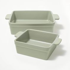 two rectangular dishes sitting side by side on a white surface, one is green and the other is grey