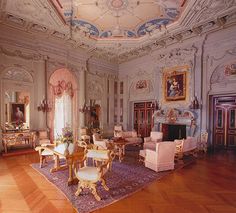 an ornately decorated living room with white walls and wood flooring is pictured in this image