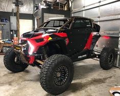 a red and black vehicle parked in a garage