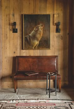 a painting hangs on the wall next to a bench