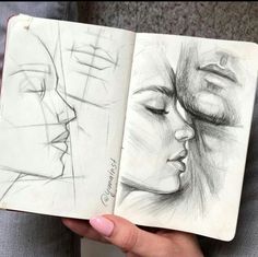 a woman's hand holding an open book with drawings on it and another drawing of a face