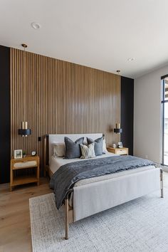 a large bed sitting next to a window in a bedroom on top of a hard wood floor