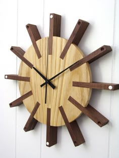 a clock made out of wood sticks on the wall