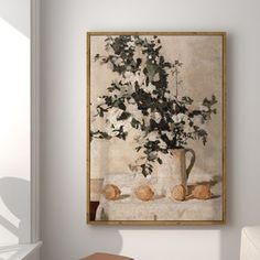 a painting hanging on the wall above a chair in a room with white walls and flooring