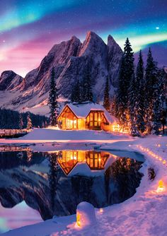 a cabin is lit up in the snow at night, with lights shining on it