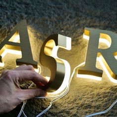 a person is lighting up the letters with their hands