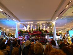 a group of people standing in front of a store filled with flowers and statues on display