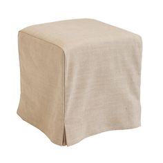 a beige ottoman cover sitting on top of a white floor