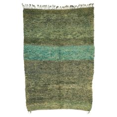 a green and blue rug with fringes on the bottom, against a white background