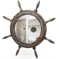 a mirror that is sitting on top of a wooden stand in front of a white wall