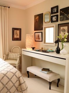 a bedroom with pictures on the wall and a white desk