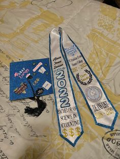 two white and blue neck ties sitting on top of a bed