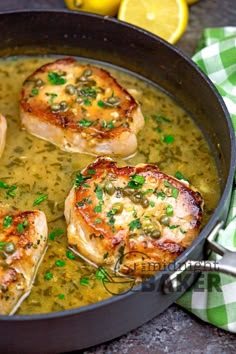 three pieces of chicken in a pan with lemons and parsley on the side