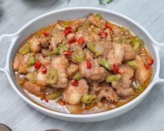 a white bowl filled with meat and vegetables