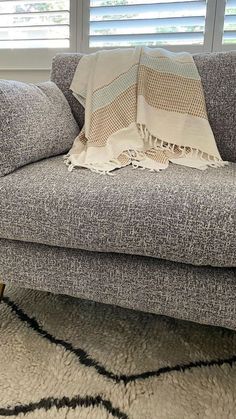 a couch with a blanket on it in front of a window