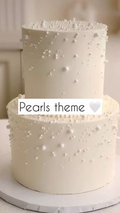 two tiered white wedding cake with pearls on the top, and words pearls theme