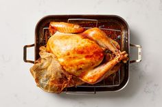 a roasting pan with a whole chicken in it