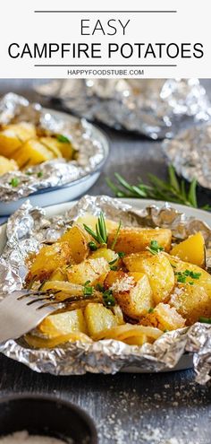 two foil packets filled with cooked potatoes on top of a wooden table next to silver plates