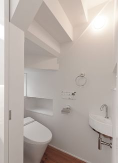 a bathroom with a toilet, sink and mirror in the corner next to a doorway