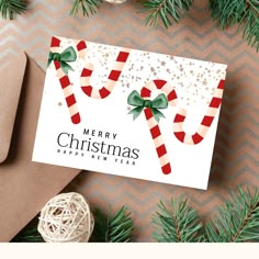 a christmas card with candy canes on it next to wrapping paper and twine