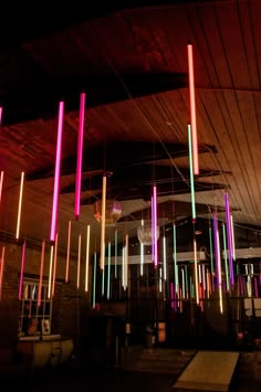 colorful lights hanging from the ceiling in a dark room