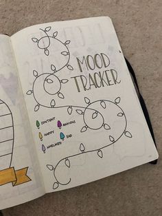 an open notebook with drawings on it and the words mood tracker written in cursive writing