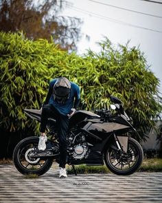 a man sitting on top of a black motorcycle