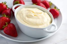 some strawberries are sitting on a plate next to a bowl of cream cheese dip