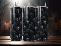 three tumbles with skulls on them are sitting on a table in front of a dark background