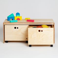 a wooden toy chest with toys in it