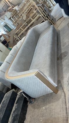 an upholstered couch sitting on top of wooden steps in a warehouse or building