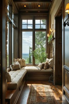 a window seat in the corner of a room with wooden floors and walls, along with a rug on the floor